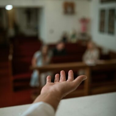 A hand reaching out in a church setting, symbolizing faith and community.